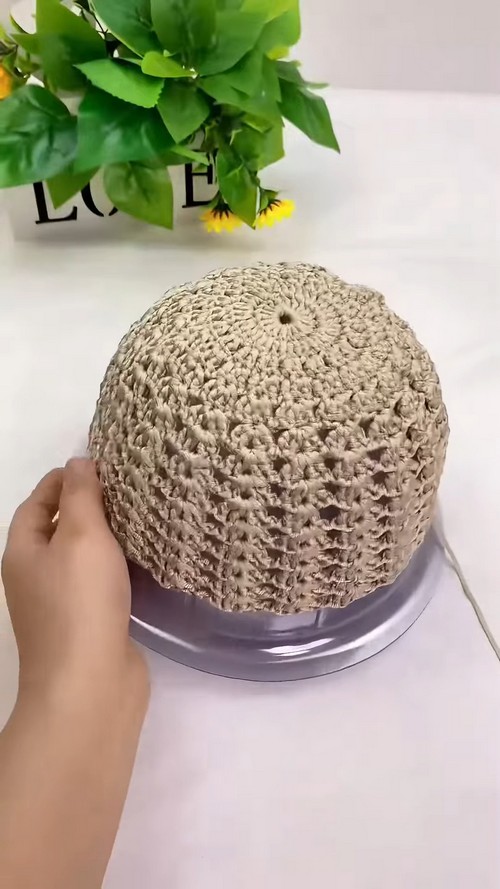 Top-down view of a crochet sun hat crown showing the shell-stitch pattern radiating from the center.