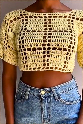 Finished pale yellow crochet summer top worn with denim shorts showing an open grid mesh body and short sleeves